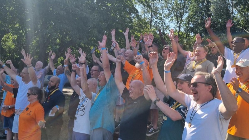 London Taxi Drivers’ Charity for Children supporters gathered outdoors with their hands raised