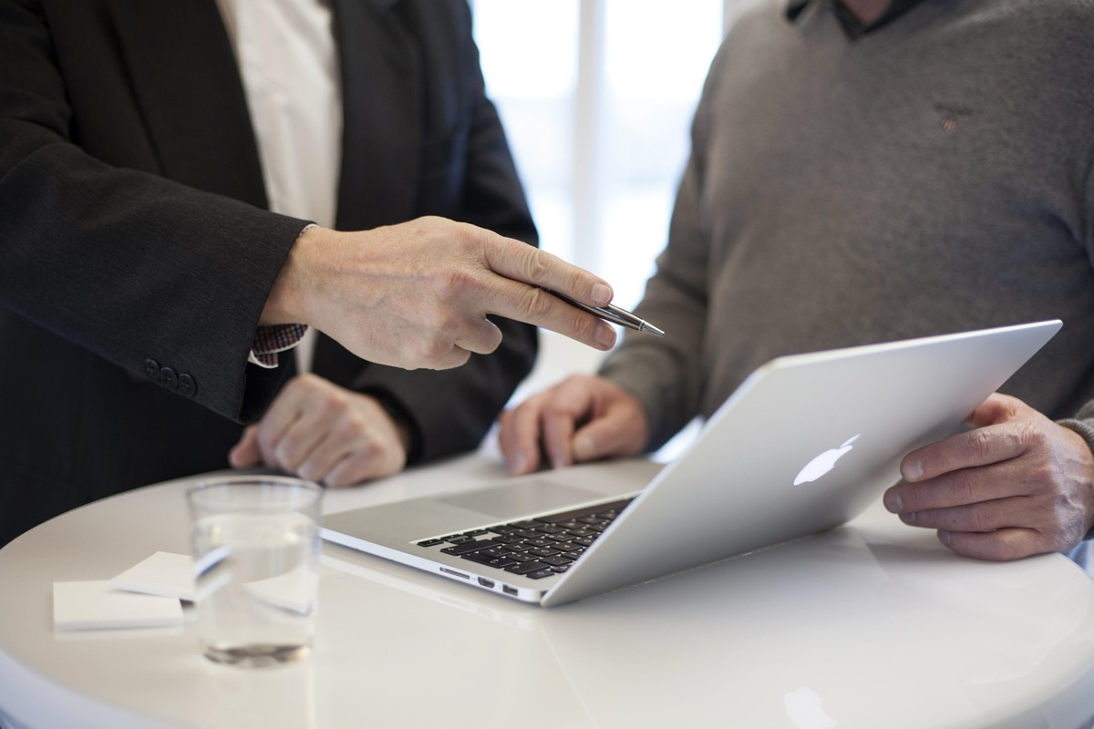 Two people reviewing information together on a laptop